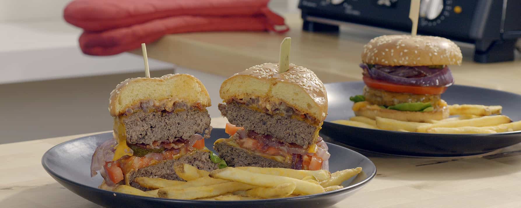 Burger and French fries are on the plate cooked, inside toaster oven