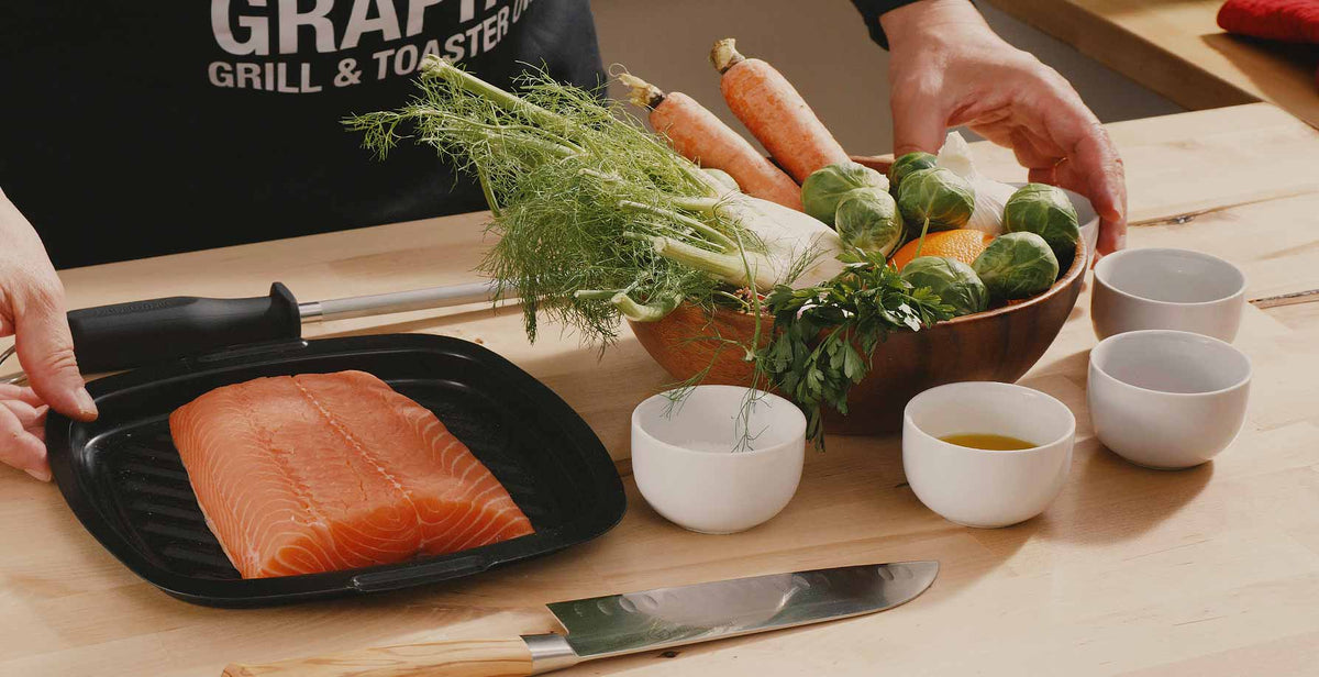 All ingredients for a baked salmon recipe are on the table with a chef standing behind. 